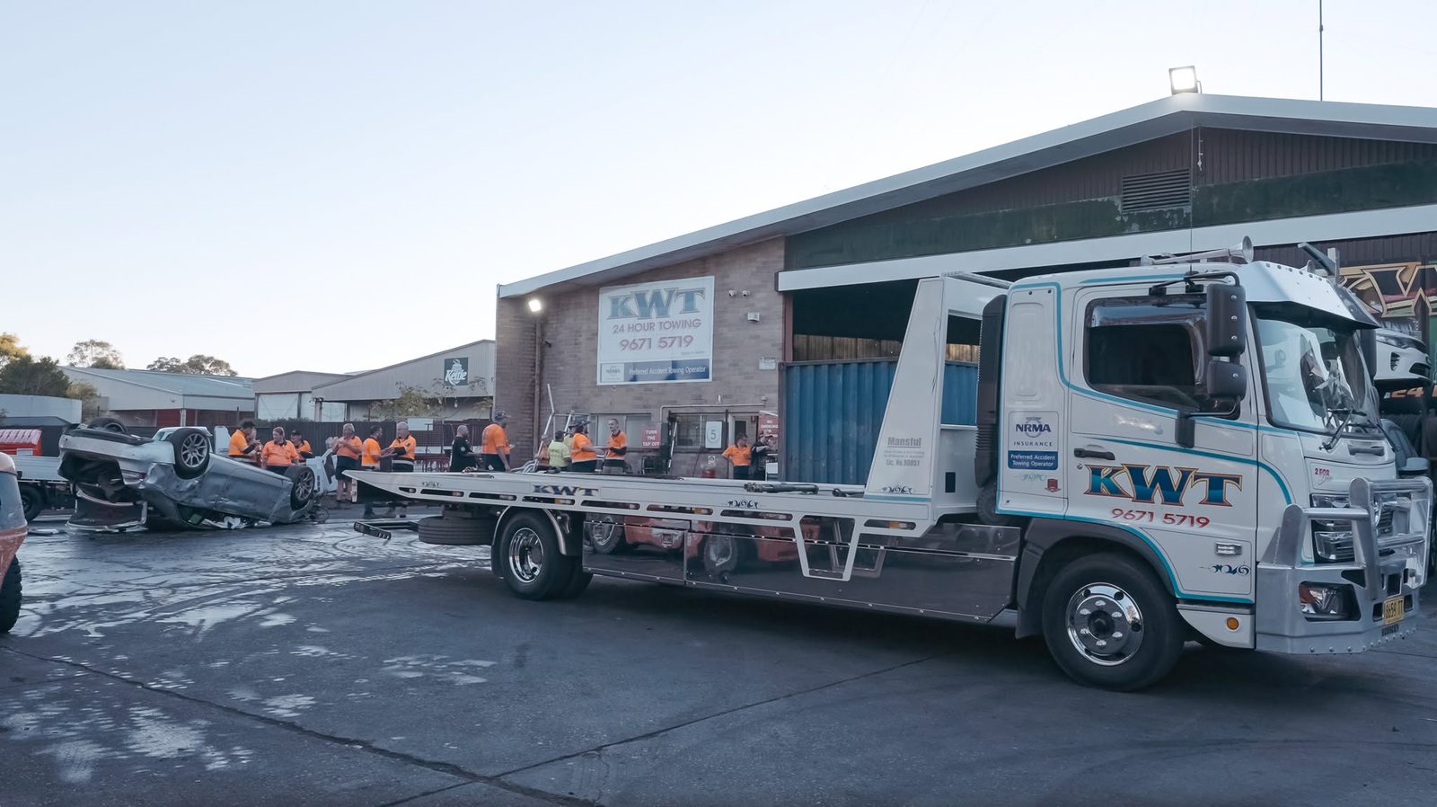 KWT driver briefing the team beside a flatbed truck