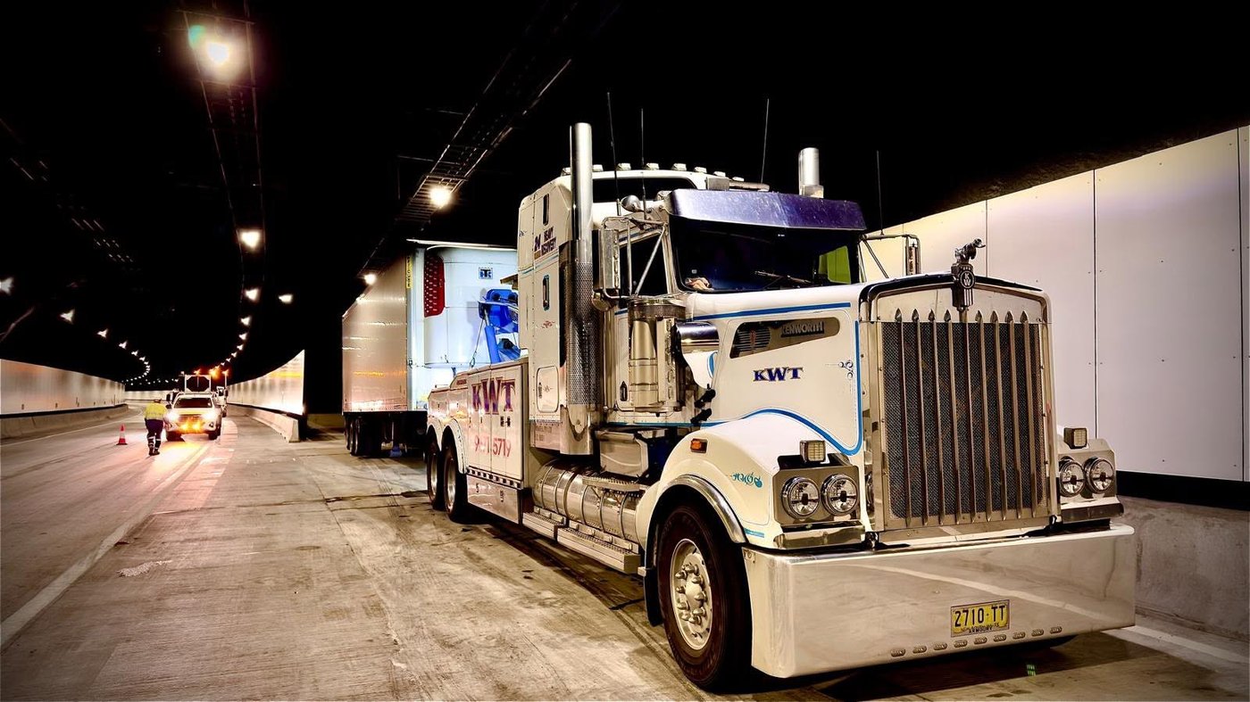 KWT heavy wrecker under-lifting a truck at night in a tunnel