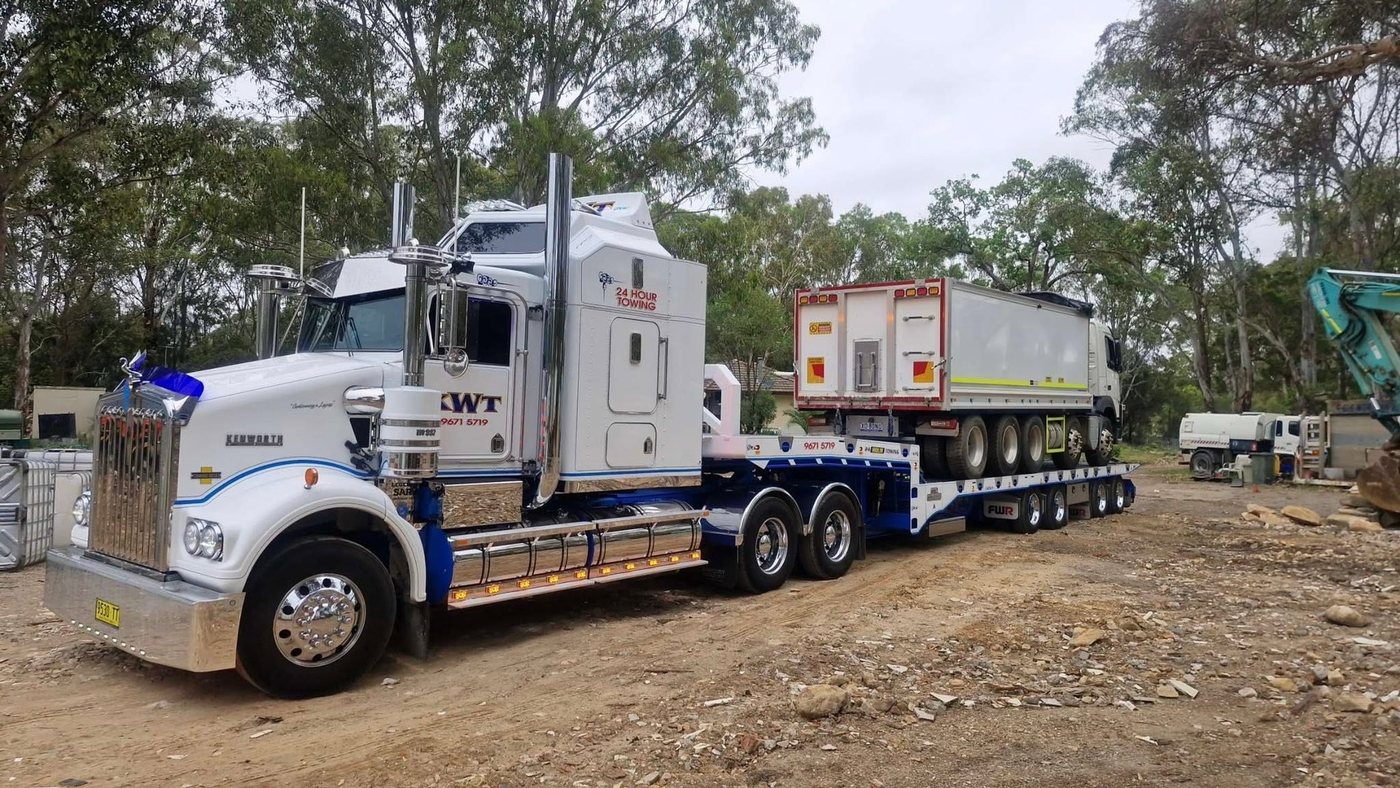 KWT truck transporting a container on a low loader