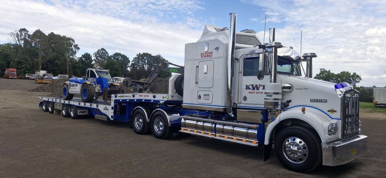 KWT low loader hauling heavy plant for a contractor