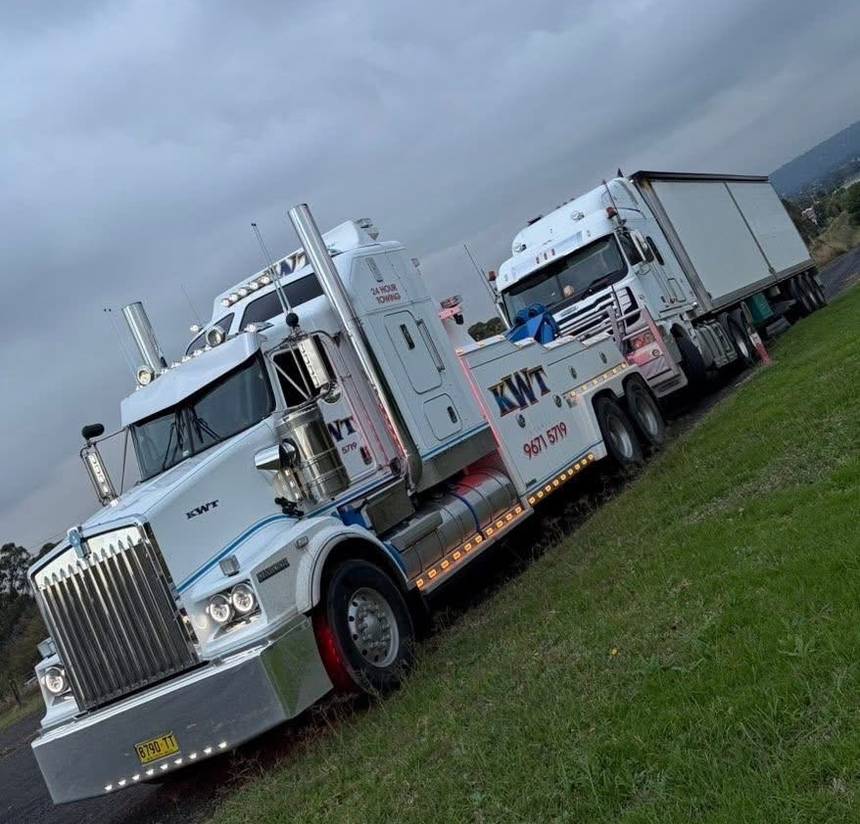 KWT heavy wrecker towing a prime mover and trailer