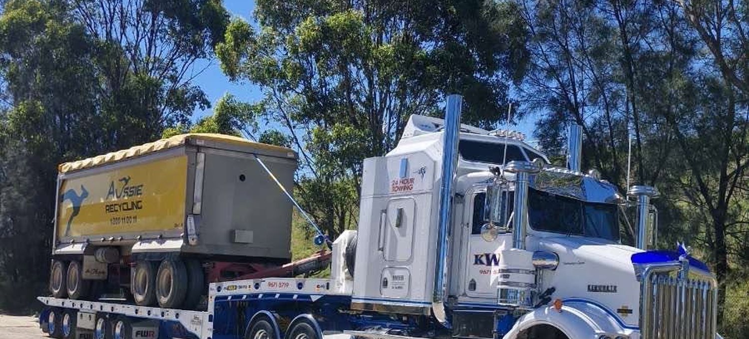 KWT low loader carrying an oversize plant item on the highway