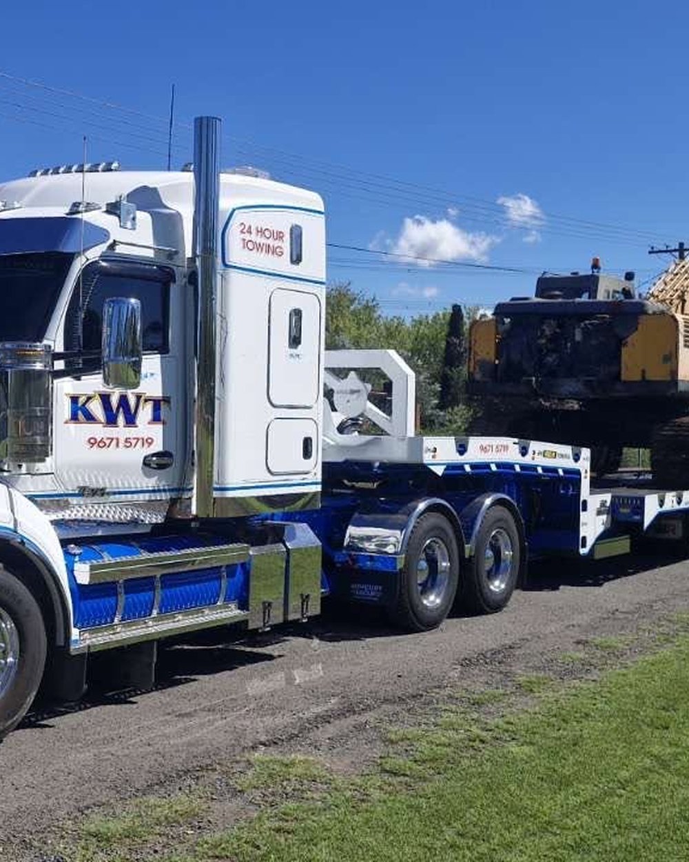 KWT prime mover with a tracked excavator loaded on a low loader trailer