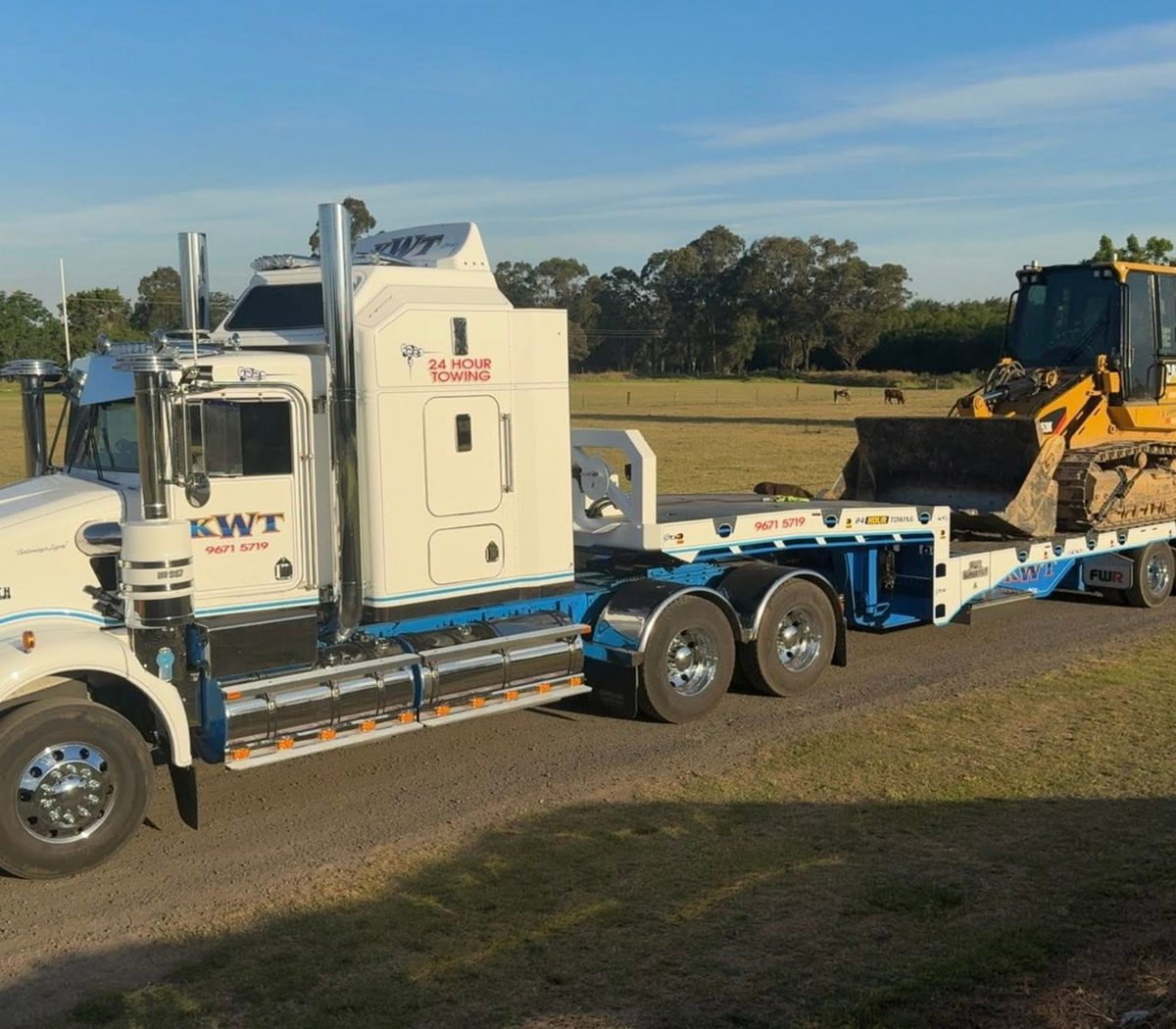 KWT low loader carrying heavy plant across a regional NSW paddock