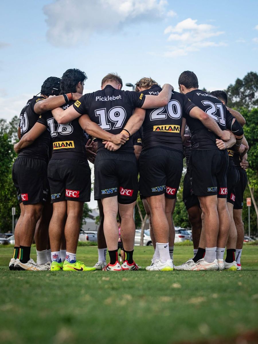 Penrith Panthers players in a huddle wearing shorts with KWT branding