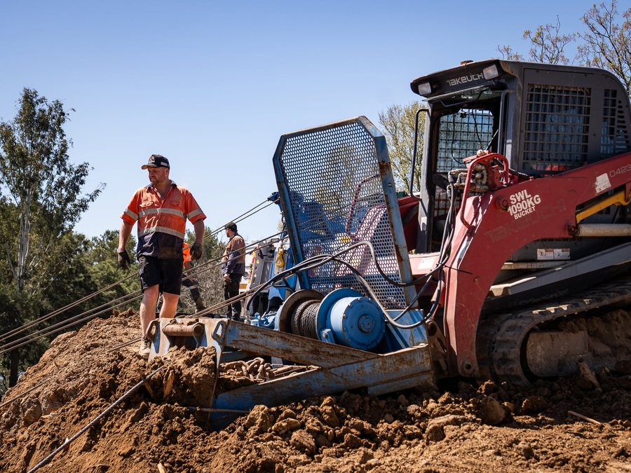 Recovery excavator and winch line positioned for extraction