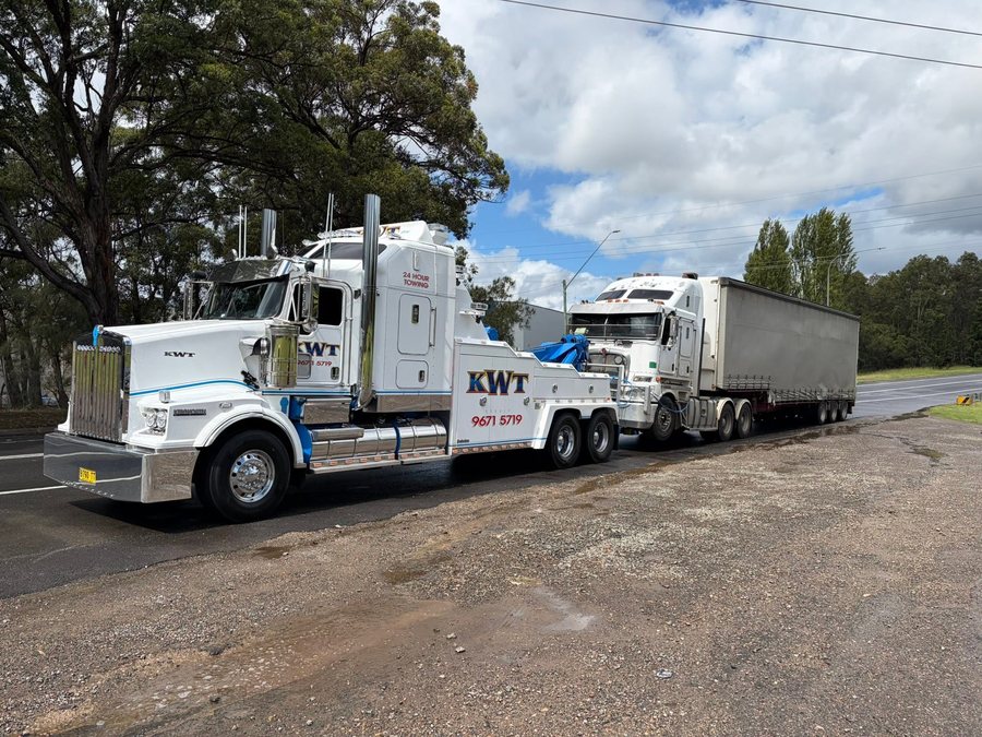 KWT truck transporting a vehicle on the road