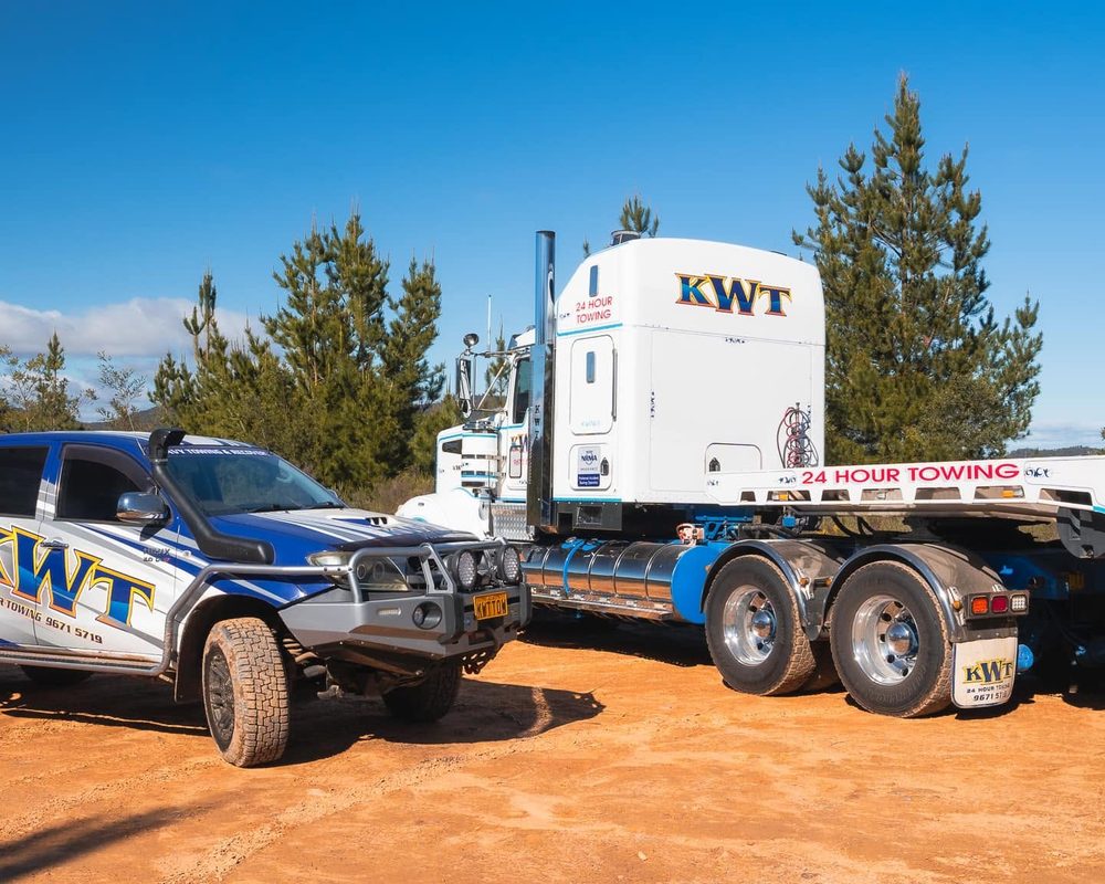 KWT flatbed carrying a passenger car