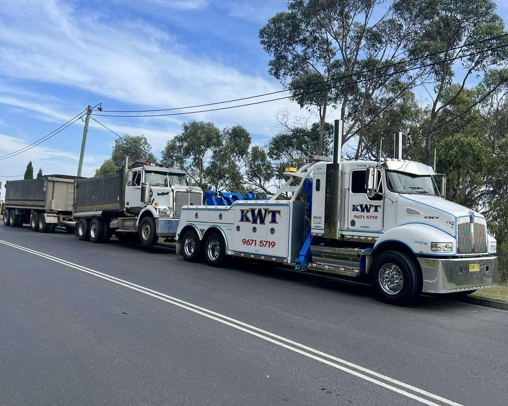 KWT truck carrying an oversize load with escort