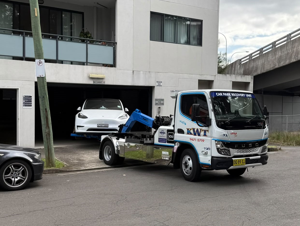 KWT flatbed carrying a car through Sydney