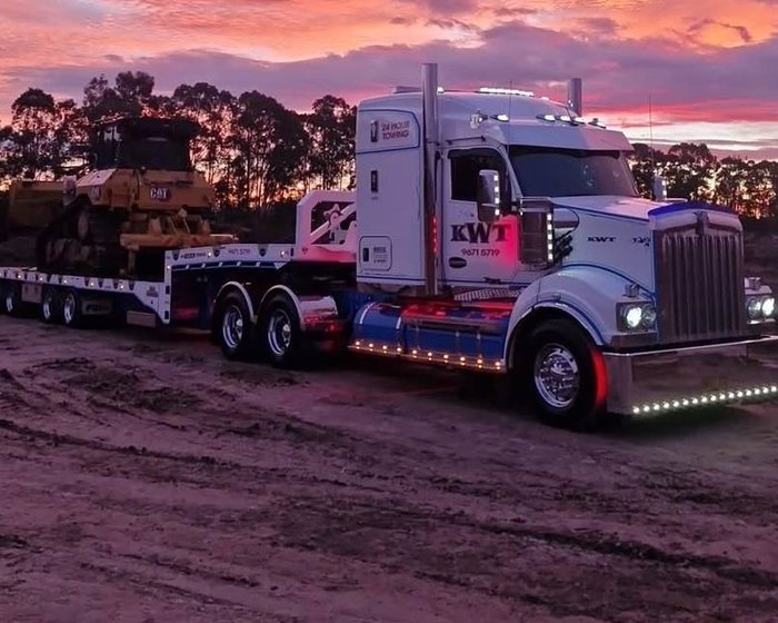 KWT prime mover transporting a CAT excavator on a low loader trailer